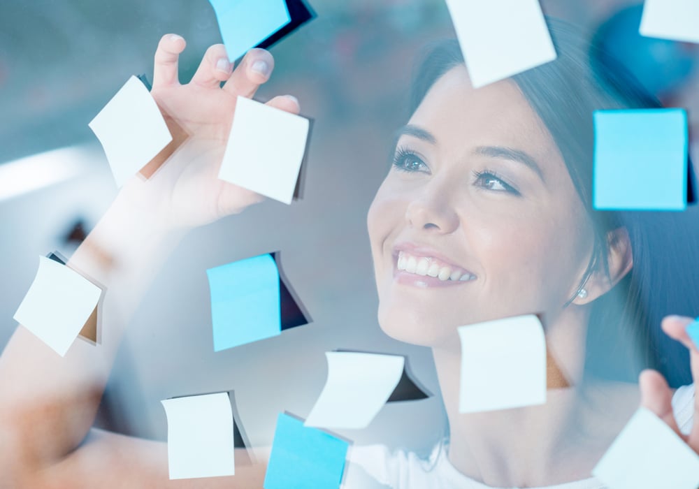 Happy woman multitasking with post-its all over the place